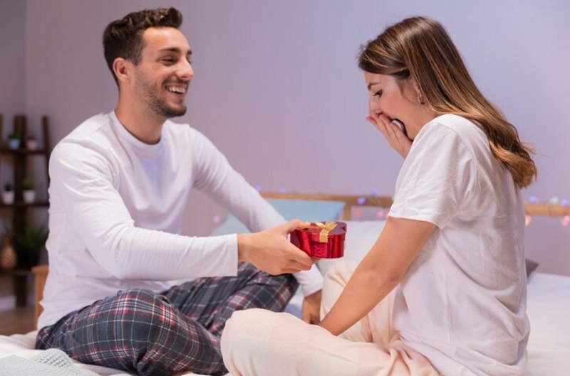 man hand holding gift and woman looking the gift